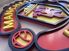 a close up of the letters and numbers on a sign that is red, yellow, and blue