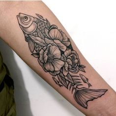 a fish and flowers tattoo on the arm