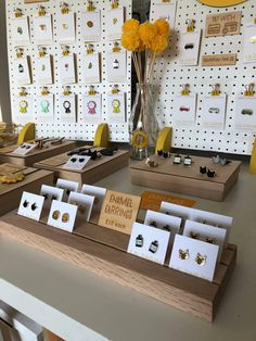 there are many earrings on display in the store with flowers and other items behind them