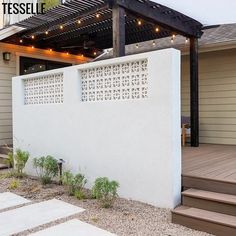 an outdoor patio with steps leading up to the front door and covered in string lights