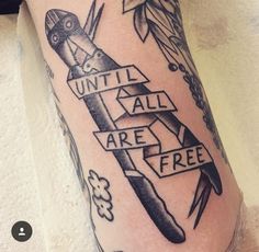 a tattoo on the leg of a woman with scissors and flowers around her ankles that says until all are free