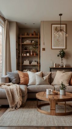 a living room filled with furniture and a large window next to a coffee table on top of a hard wood floor