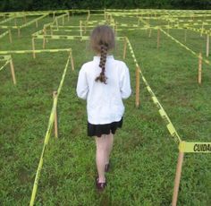 a woman walking through a field with yellow caution tape