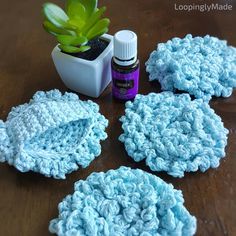 crochet scrub cloths with a bottle of essential oil next to them on a table