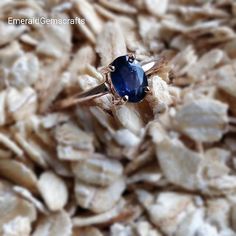 a blue ring sitting on top of a pile of wood chips