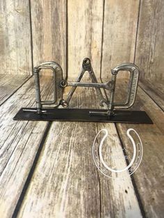 a metal object sitting on top of a wooden table next to a horseshoe shaped like a horse shoe