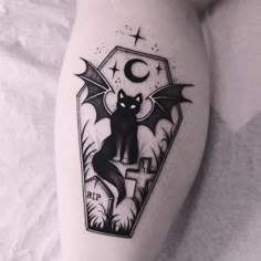 a black cat sitting on top of a white bed next to a cross and moon