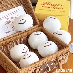 four white balls with faces are in a wicker basket