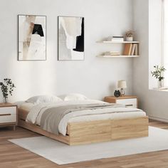 a bed sitting in a bedroom next to two pictures on the wall and a white rug