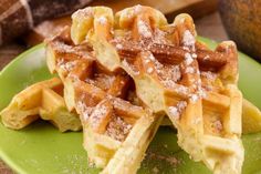 some waffles on a green plate with powdered sugar