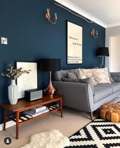 a living room with blue walls and white rugs on top of the carpeted floor