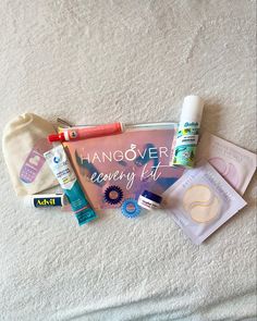 an assortment of personal care items laid out on a towel with the words hangover recovery kit