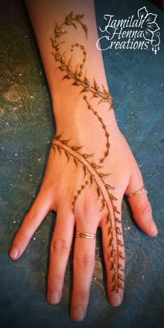 a woman's hand with an intricate design on the wrist and palm, which is decorated