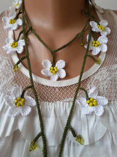 a mannequin with white and yellow flowers on it's neckpieces