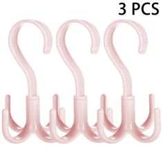 four pink plastic hooks are shown in three different positions, one is hanging on the wall