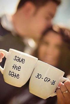 two coffee mugs with the words save the date written on them are held by a man and woman