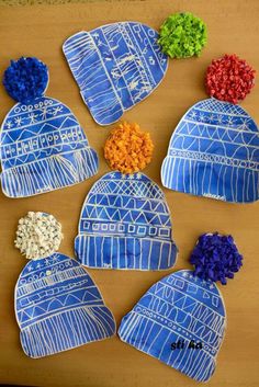 four hats made out of paper with flowers on them, all in blue and white