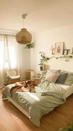 a bed sitting in a bedroom next to a window and a chair on top of a hard wood floor