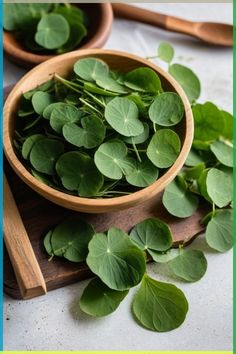 some green leaves in a wooden bowl on a table