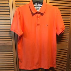 Orange Slim Fit Polo Shirt With 2 Button Front, Logo On The Left Front, Ribbed Collar And Cuffs And Splits On The Sides. Size Xl. Measures 24” From Underarm To Underarm And 32” From Shoulder To Bottom. 97% Cotton 3% Elastane. Nwt Solid Spring Polo Shirt With Button Closure, Solid Polo Shirt With Button Closure For Spring, Classic Orange Short Sleeve Shirt, Classic Orange Tops For Spring, Classic Orange Buttoned Top, Classic Orange Collared Top, Classic Orange Tops With Buttons, Tommy Hilfiger Button-up Summer Tops, Tommy Hilfiger Summer Button-up Top