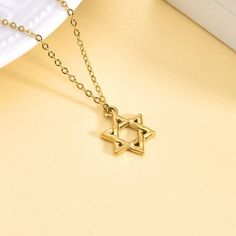 This 18K Gold Plated Star of David Necklace offers a timeless blend of tradition and elegance. Featuring a beautifully crafted Star of David pendant on a dainty gold chain, this necklace is perfect for both daily wear and special occasions. The adjustable chain ensures a comfortable fit, making it a versatile and meaningful addition to any jewelry collection. Features: Material: 18K gold-plated stainless steel Pendant Design: Star of David Chain Length: 16 inches + 2 inches extension (40 cm + 5 Dainty Gold Chain, Star Of David Necklace, Star Of David Pendant, Stainless Steel Pendant, Star Of David, Pendant Design, Chain Lengths, Pendant Necklaces, Gold Chains