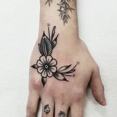 a woman's hand with a flower tattoo on it