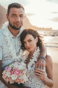 a man and woman standing next to each other on the beach