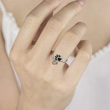 a woman wearing a ring with a dog paw on it