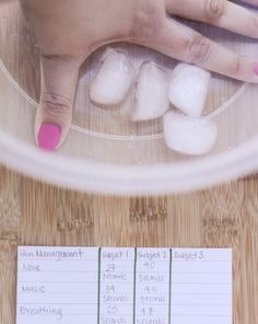 a woman's hands with pink fingernails and manicures on top of a wooden table