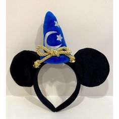 This Adorable Mouse Ears Headband Featuring The Iconic Sorcerer Mickey Mouse Is A Must Have For Any Disney Fan! The Unisex Design Makes It Suitable For Both Adults And Children, And The One-Size-Fits-All Ensures A Comfortable Fit. Features Plush Black Ears With Fabric Covered Headband, Blue Sorcerer’s Hat With White Embroidered Moon & Stars, And Detachable Gold Cord. This Contemporary Collectible Will Never Go Out Of Style And The Hairband Is An Excellent Accessory To Add To Your Disney Apparel Embroidered Moon, Mickey Mouse Ears Hat, Disney Apparel, Sorcerer Mickey, Headband Hat, Mouse Ears Headband, Mickey Mouse Ears, Ears Headband, Disney Fan