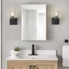 a bathroom vanity with two lights and a mirror above it