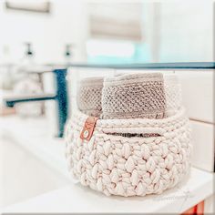 two knitted baskets sitting on top of a counter