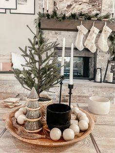 a christmas tree and other decorations on a wooden tray in front of a fire place