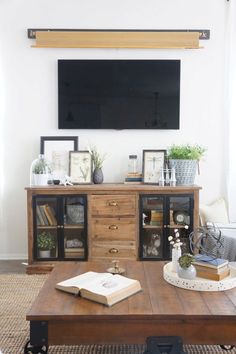 a living room with a tv and books on the table in front of it's entertainment center