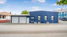 a blue building with two garages on the street