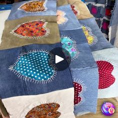 a table topped with lots of different types of quilts on top of each other