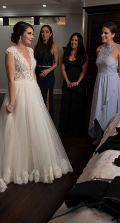 the bride is getting ready to walk down the aisle in her wedding dress with friends