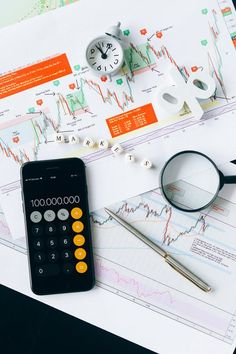 a calculator, magnifying glass and eyeglasses on top of papers