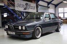 an old bmw is parked in a garage