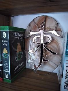 a book shelf filled with books next to a glass mask on top of each other