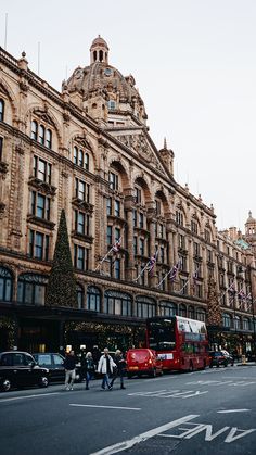 people are walking down the street in front of some very tall buildings with christmas decorations on them