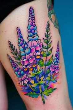 a woman's thigh with flowers and leaves painted on the side by tattoo artist