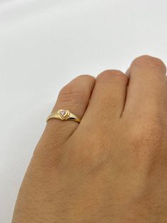 This cute small 14K gold heart signet ring is the perfect size for a baby, child, or pinky ring for women. The center stone is a simulated pink or white diamond (Cubic Zirconia). The ring is made of 100% 14K gold. It's a beautiful ring for a little girl or a gorgeous pinky ring. Ring pictured on a small child's hand and woman's 2 1/2 pinky finger Stamped 14K gold Cubic Zirconia Stone Small sized ring Visit us on Instagram @agoldmindjewelry for our custom jewelry designs and newest listings ▬ All Pinky Gold Ring, Little Finger Rings For Women, Pinky Ring Aesthetic, Signet Ring With Stone, Pinky Ring For Women, Pinky Rings For Women, Heart Signet Ring, Ring With Stone, Pinky Finger