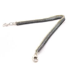 a silver and black beaded necklace on a white background