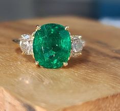 Gorgeous Vintage 14k yellow gold green natural emerald engagement ring GIA cert laboratory.  center natural emerald weight 3.92ct. Size 10.9x9.3mm very nice quality emerald,Very nice cut, rich medium green color,clean, lively. side two natural round diamonds total weight   1.20ct. SI2 clarity Size 5.1mm top light brown  Ring SIZE 6.5 Resizable  Retail value $11,500 net. Appraisal available Luxury Oval Engraved Emerald Ring, Luxury Green Oval Engraved Ring, Emerald Ring Designs Unique, Emerald Oval Engagement Ring, Vintage Emerald Engagement Rings, Round Emerald Ring, Emerald Engagement Ring Vintage, Vintage Emerald Engagement Ring, Brown Ring