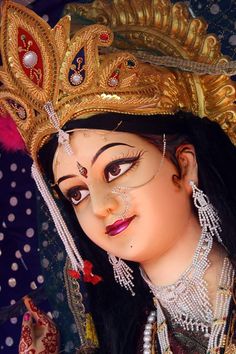 a close up of a woman wearing a headdress and jewelry on her face