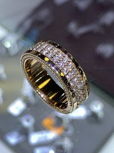 a diamond ring sitting on top of a glass table next to a cell phone screen