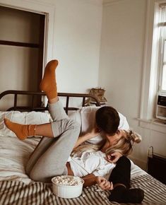 a man and woman laying in bed with their feet on each other's head