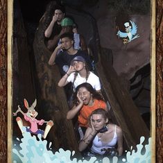 a group of people riding on top of a wooden slide at an amusement park or water park