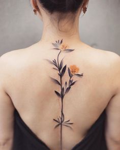 the back of a woman's neck with flowers tattooed on her upper and lower back